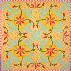 May Basket - "Floral" Collection - Pattern - # Q05 - This quilt is reminiscent of the old May Day tradition of filling a paper basket with the first flowers of spring and hanging it on the door of an unsuspecting neighbor. As a child, this was right up there with hunting for Easter eggs. After knocking on the door, my friends and I would hide and wait for the surprised expressions of the lucky recipients. What a simple life! The May Basket quilt combines appliquéd floral blocks (set “on point”) and strip piecing for the border. It also uses “straight of grain” setting triangles to keep it from becoming wavy along the outer edges. 